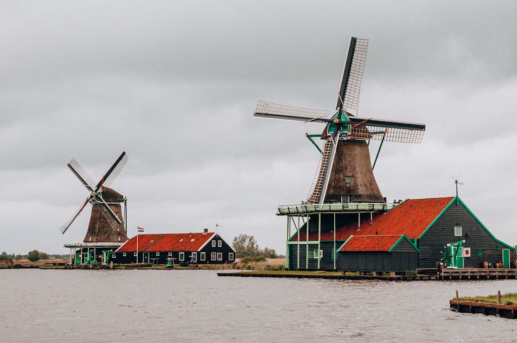 Scenic view of historical windmills by the river in Kinderdijk, Netherlands.